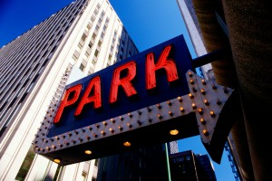 Close-up of a lighted PARK sign with a lighted arrow.