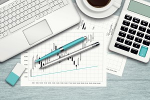 workspace with graph, computer, graph, calculator and stationery