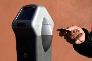 Hand Ready to Swipe Card at Parking Meter (Close-Up)